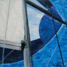 Bleu, blanc, noir et gris : la mer, un bout de voile et de spi, et un tronçon de mât...